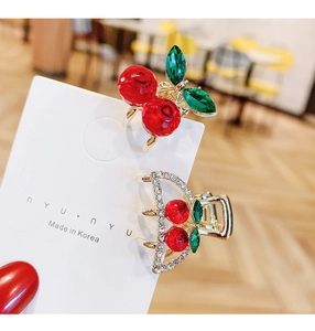 Detail of red cherry hair claw clip set on display card with gold-tone alloy and rhinestones