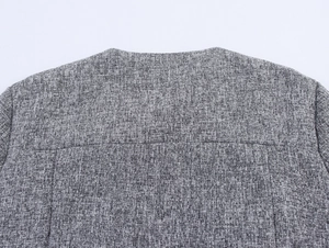 Close-up of the woven gray tweed texture and back stitching on the collar area