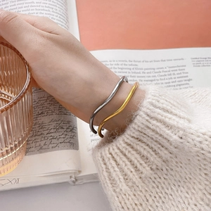 Minimalist wavy open cuff bracelets in polished gold and silver finishes for women