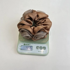 Detail showing high-quality double-layered satin hair scrunchie weighing 45.5g on a scale