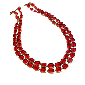 Double-layered beaded necklace with red square glass beads in gold frames on white backdrop