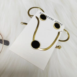 Gold stainless steel double butterfly jewelry set with black round pendants on faux fur