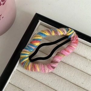 Close-up of colorful yarn wrapped cloud-shaped hair clip with vibrant knit texture