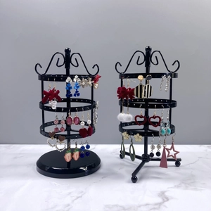 Rotating tiered black metal earring display stand with circular hooks and tripod base