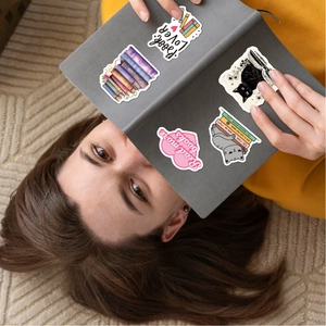 Detail of waterproof reading stickers with book and cat motifs on a grey notebook