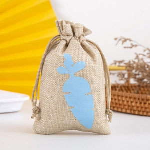 Detail view of a beige linen drawstring gift bag with a blue carrot shape applique