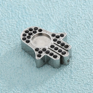 Macro shot of silver Hamsa hand pendant with black micro zircons and central groove detail