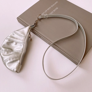 Detail shot of silver faux leather croissant mini bag necklace with zipper closure