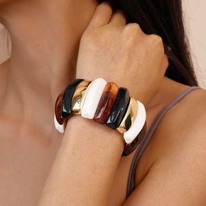 Chunky acrylic bangle featuring black, white, gold and tortoiseshell resin panels