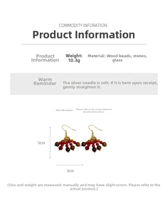 Detail of bohemian earrings with red glass beads, wood accents and silver needles