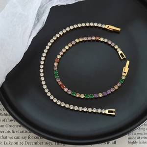 Luxury gold tennis bracelet set with white and colorful cubic zirconia on black plate