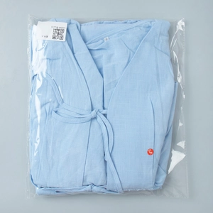 Light blue V-neck tie-front top folded in packaging showing material detail and size label