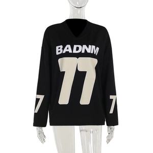 Close-up of black oversized sweatshirt featuring white and beige 77 graphic print