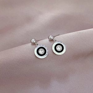 Macro detail of silver stud earring with black enamel, crystal and Roman numerals