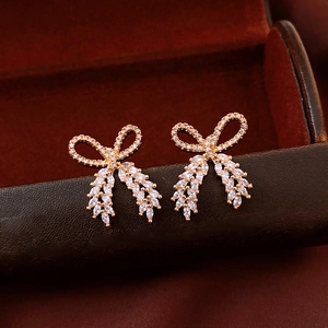 Macro shot of rose gold bowknot earrings with marquise-cut cubic zirconia tassels
