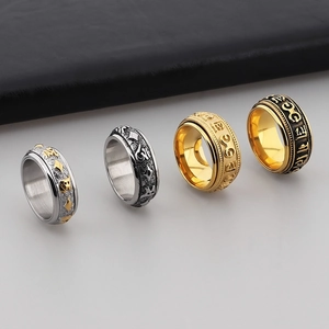 Vintage stainless steel spinner ring with relief patterns in gold, silver, and black tones