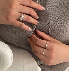 Stacked 925 sterling silver knotted and twisted rings shown on model's hand