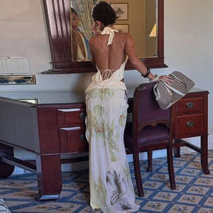 Detail view of backless halter top and floral maxi skirt with slit in elegant room