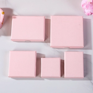 Pink textured jewelry gift boxes in various rectangular sizes on marble background