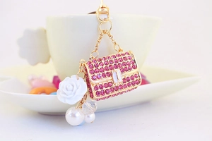 Detail of pink rhinestone handbag keychain with white rose and pearl charms decoration