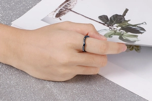 Gros plan d'une bague bleue en V ornée de cristaux portée sur la main d'un mannequin