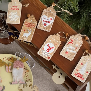 Close-up of rustic Christmas wooden tags with red and white prints on dark wood