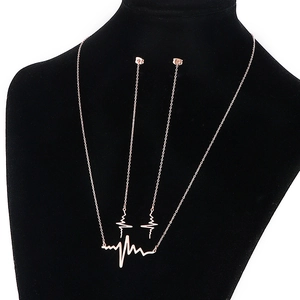 Rose gold heartbeat jewelry set with necklace and lightning earrings on black bust