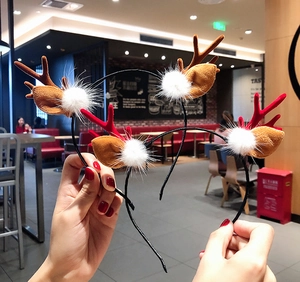 Detail of Christmas reindeer antler headbands with plush balls and brown ears decoration