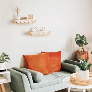Close-up of wall-mounted wooden shelves with handmade white boho cotton rope tassels