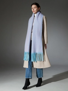 Detail of lavender plush scarf featuring soft light blue tassels and looped yarn texture
