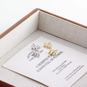 Detail of silver and gold opal stud earrings set in a premium jewelry display box
