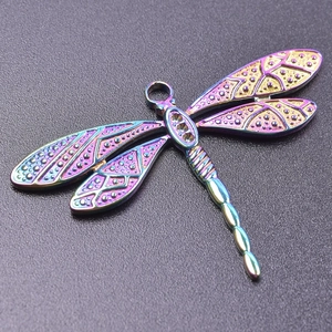Macro shot of iridescent rainbow dragonfly pendant with smooth metallic texture and hole