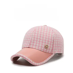 Détail de casquette pied-de-poule rose avec logo M en strass et visière courbée