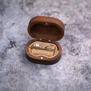 Detail of walnut wood double ring box with linen lining and two elegant rings
