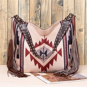 Detail of bohemian woven tote bag showing geometric patterns and brown leather strap