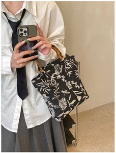 Detailed close-up of a jacquard canvas bag featuring bamboo handles and floral embroidery