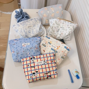 Flat lay of multiple blue canvas makeup bags with diverse floral and cartoon prints