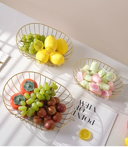Detailed close-up of golden iron fruit baskets in oval boat shape on marble table