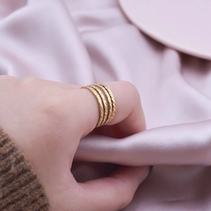 Minimalist gold multilayer stainless steel geometric ring on soft silk background