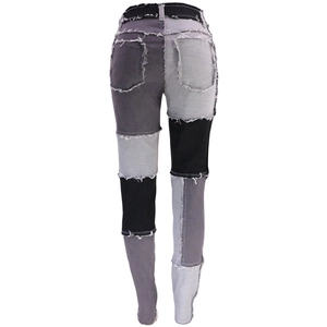Dettaglio dei jeans patchwork a vita alta con bordi sfrangiati e pannelli multicolore