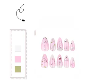 Detail of pink almond press-on nails featuring 3D bows, pearls, and star rhinestones