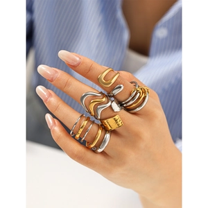 Detail view of bold gold and silver stainless steel rings with lava texture on hand