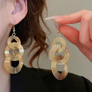 Golden multi-layer spiral loop drop earrings featuring elegant metal wire tassels