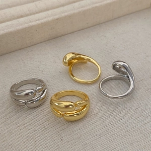 Polished double-layered minimalist gold and silver rings with fluid organic droplet shapes