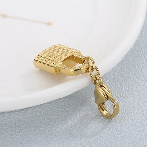 Détail macro d'un pendentif sac à main matelassé plaqué or avec fermoir mousqueton