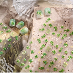 Macro view of four-leaf clover nail stickers with gold stars and green motifs