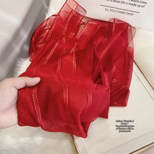 Detail of red silk wool scarf with metallic gold stripes and sheer texture