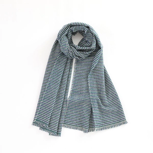 Detail shot of the vintage houndstooth scarf texture in blue and white with fringe tassels