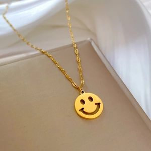 Nahaufnahme der vergoldeten Titanstahl-Halskette mit rundem Smiley-Anhänger im Minimal-Stil