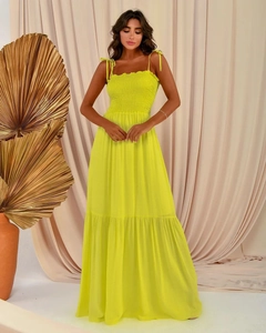 Detail of a bright yellow tiered maxi dress featuring a pleated bust and bow shoulder straps